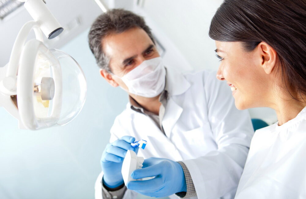 Dentist showing how to brush teeth